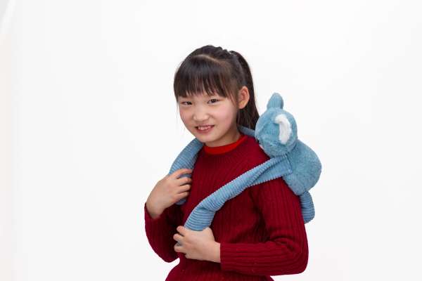 Barn holder Koala Little Hugger i blå foran – omsluttende tyngdebamse til sanselig regulering

