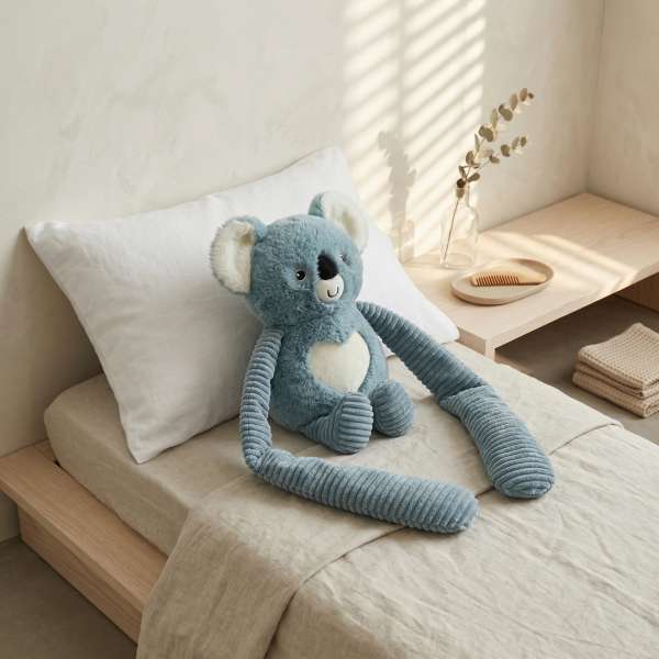 Koala Little Hugger i blå på seng – beroligende tyngdebamse til ro og hvile

