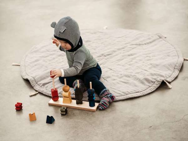 Barn leger med stablelegetøj og snor – kreativ aktivitet til fordybelse og motorik

