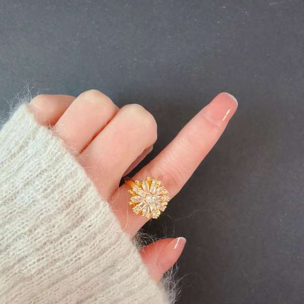 Gazania fidgetring båret på fingeren – elegant guldfarvet fidgetsmykke til koncentration, ro og diskret fidgeting.