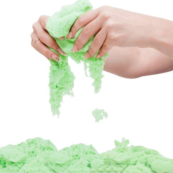 Grønt Magic Sand, der flyder mellem hænderne – kinetisk sand til taktil stimulering og sanselig leg.