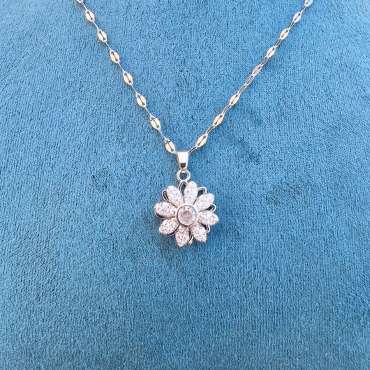 Camelina fidgethalskæde med blomsterformet vedhæng i sølvfarvet rustfrit stål og funklende hvide zirkoner – elegant fidgetsmykke til diskret fidgeting, ro og koncentration.

