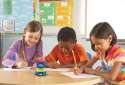 Time tracker mini på et bord i et klasselokal, hvor det hjælper 3 børn med at hold styr på tiden 
